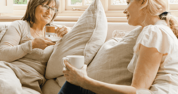 women on couch drinking coffee